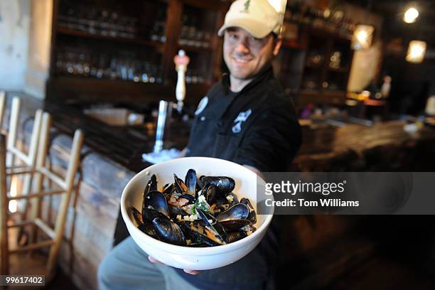 Teddy Folkman, executive chef/owner of Granville Moore's, displays a serving of Moules Fromage Bleu, which are mussels with bacon and bleu cheese, at...