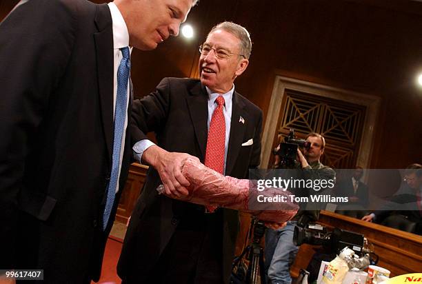 Sen. Chuck Grassley, R-Iowa, holds up a piece of beef, while talking to Ambassador Allen Johnson, Chief Agricultural Negotiator, before a hearing of...