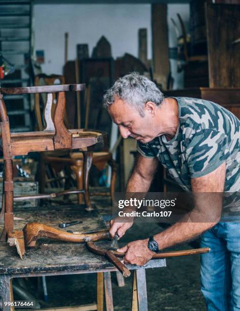 timmerman herstel van een oude houten stoel - carlo107 stockfoto's en -beelden