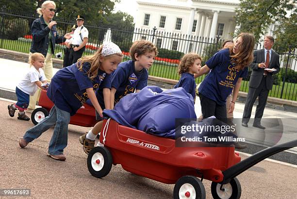 Bella Juzenas and Max Jerald Casey Bolanos push a wagon full of petitions to deliver to the gates of the White House to protest President Bush's veto...