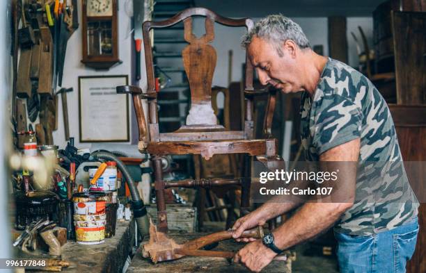 timmerman herstel van een oude houten stoel - carlo107 stockfoto's en -beelden