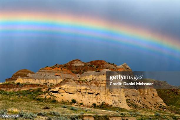 rainbow over colorful badlands, eroded rock formation of sedimentary rock, dinosaur provincial park, unesco world heritage site, alberta province, canada - yacimiento fósil fotografías e imágenes de stock