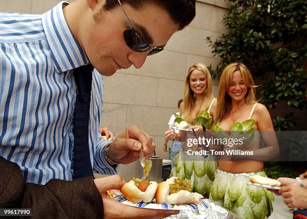 Leo Wood of the Kato Institute, puts relish on vegetarian hotdogs he received from former Playboy Playmates Lauren Anderson, left, and Kari Kennell,...