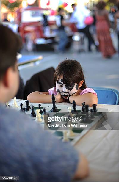 Emily Moritsugu of Great Falls, contemplates her next move during chess match with her brother-in-law Brian Kernek of Capitol Hill, at H Street...