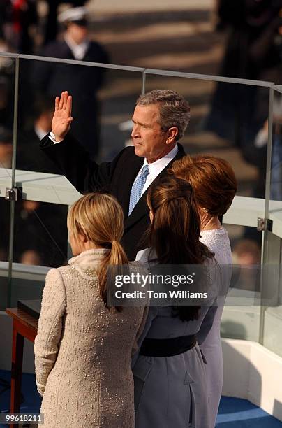 George W. Bush is sworn into a second term at the 55th Presidential Inauguration. From left are daughters, Jenna, Barbara and his wife Laura.