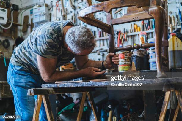 timmerman herstel van een oude houten stoel - carlo107 stockfoto's en -beelden