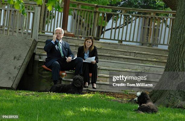 Sen. Ted Kennedy, D-Mass., talks on his cell phone with an aide and his two dogs, at the press area in Upper Senate Park.