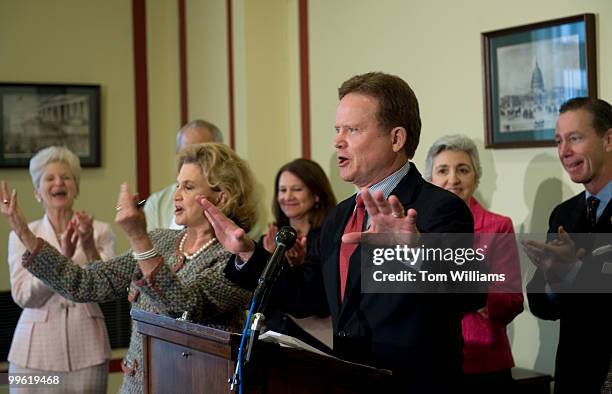 Sen. Jim Webb, D-Va., tries to settle applause upon his arrival at the podium during a news conference with Reps. Carolyn Maloney, D-N.Y., left, and...