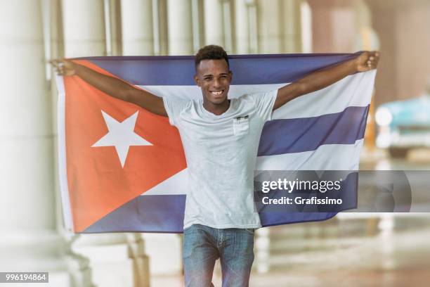 cuban man walking with cuban flag through old havana - grafissimo stock pictures, royalty-free photos & images