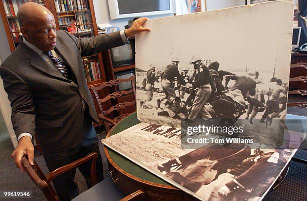 Rep. John Lewis, D-Ga., shows pictures of police attacking himself and other marchers on Bloody Sunday in Selma, Alabama.