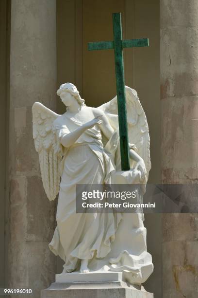angel with a cross, sculpture at karlskirche church, karlsplatz square, vienna, austria - karlskirche stock-fotos und bilder