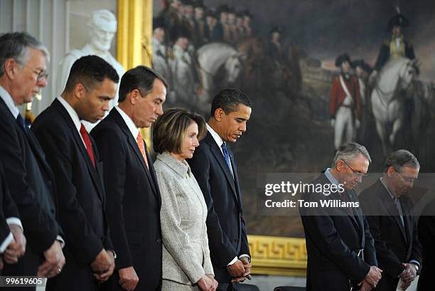 President Barack Obama, fourth from right, bows his head for the invocation for a ceremony honoring the 200th birthday of Abraham Lincoln, February...