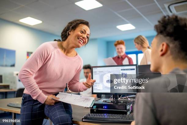 helping her student with his project - student achievement stock pictures, royalty-free photos & images