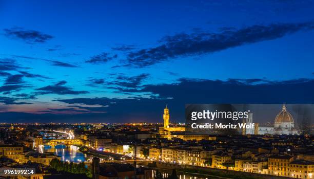 illuminated city panorama at dusk with florence cathedral, duomo santa maria del fiore with the dome by brunelleschi, palazzo vecchio, ponte vecchio, unesco world heritage site, florence, tuscany, italy - fiore stock-fotos und bilder