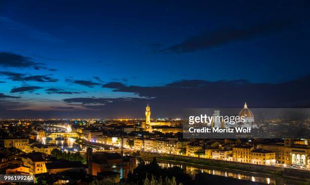 illuminated city panorama at dusk with florence cathedral, duomo santa maria del fiore with the dome by brunelleschi, palazzo vecchio, ponte vecchio, unesco world heritage site, florence, tuscany, italy - fiore stock-fotos und bilder