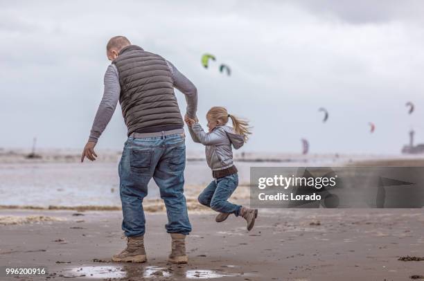 ensamstående far och hans dotter spela familj spel på en vinter strand - scheveningen bildbanksfoton och bilder