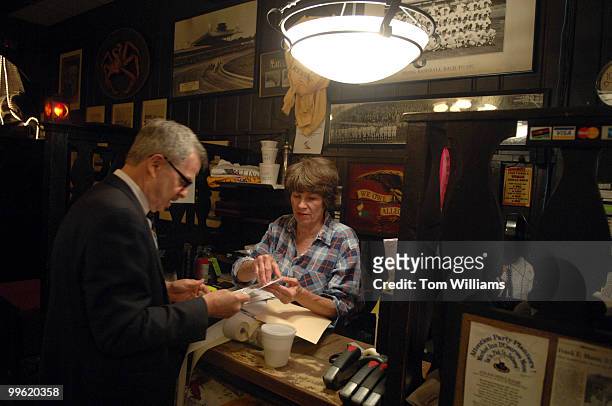 Carl Mandis, owner of the Market Inn restaurant at 200 E Street, SE, and his sister Elizabeth Whitehill, go through files at the cash register.