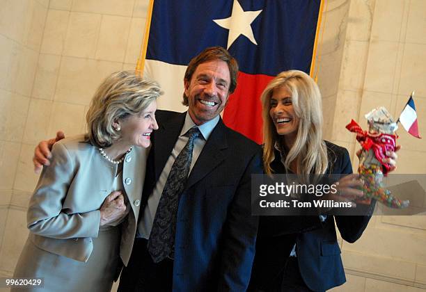 Actor Chuck Norris, his wife Gena, right, and Sen. Kay Bailey Hutchison, R-Texas, talked to the media in front of the flag of Texas in Russell...