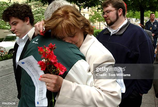 Liz Mattingly, wife of the late Captain Joseph A. Mattingly, hugs John Paul Quinn, a former boss of Captain Mattingly at the Montgomery County Police...