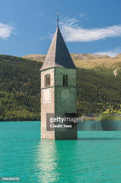 steeple, bell tower of the submerged church of the village of alt-graun in lake reschen, or reschensee lake, graun, vinschgau, curon venosta, south tyrol, trentino-alto adige, italy - alt stock pictures, royalty-free photos & images