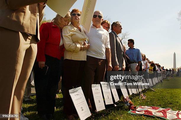 Brenda Roberts puts her head on the shoulder of her mother Sandra Sadchik while listening to names beign read of people who died as a result of there...