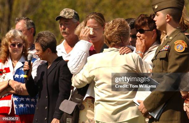 Amy Bentos is comforted by her mother Carolyn after they read the name of the father and husband to the two, Lloyd Barry Bentos, who died in 2003....