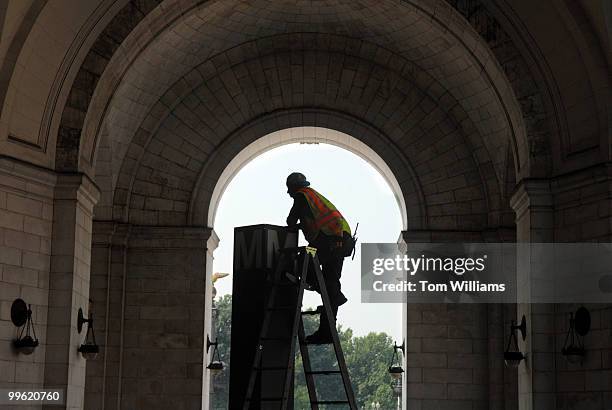 Que Dawson, a Metro employee, fixes a light in that illuminates the sign at the top of the Union Station stop.