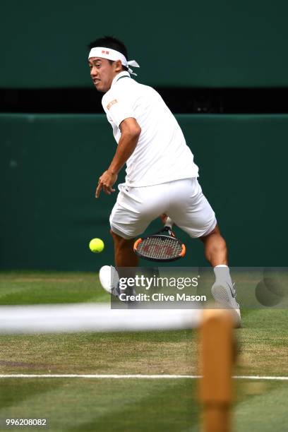 Kei Nishikori of Japan plays a shot through his legs against Novak Djokovic of Serbia during their Men's Singles Quarter-Finals match on day nine of...