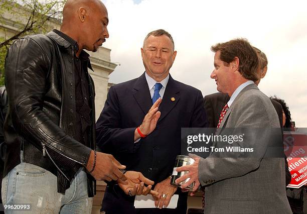 Rep. Dana Rohrbacher, R-Calif., makes a motion to Irvin Rosenfeld, of Fla., right, who suffers from a bone condition, and Montel Williams, a multiple...