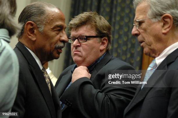 Filmmaker Michael Moore, center, attends a news conference with Chairman of the House Judiciary Committee John Conyers, D-Mich., left, and Rep. Pete...