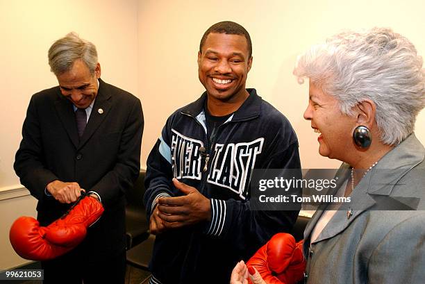 Reps. Charlie Gonzalez, D-Texas, and Grace Napolitano, D-Calif., try on their new gift, boxing gloves, from Sugar Shane Mosley, super welterweight...