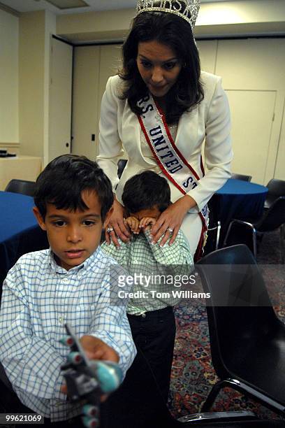 Mrs. United States 2004 Edrienne Carpenter, watches over her children Logan left, and Austin before she spoke at a news briefing about her personal...