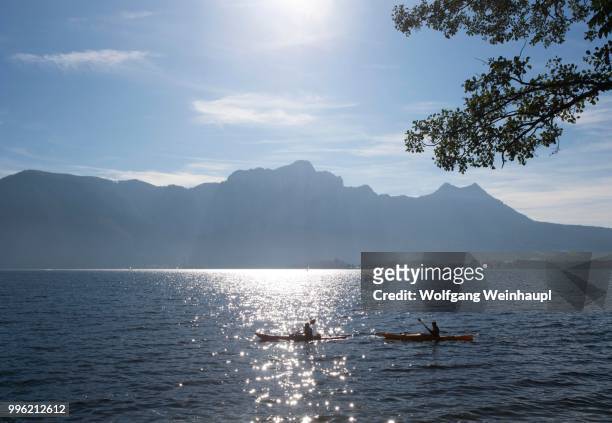 canoeists on lake mondsee with drachenwand and schober, mondsee, salzkammergut, upper austria, austria - vocklabruck stock pictures, royalty-free photos & images