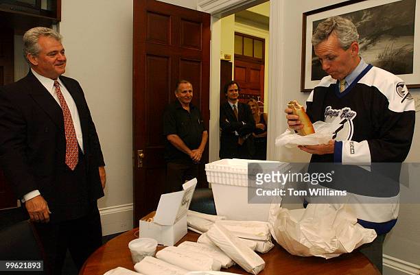 Rep. Robert Brady, D-Pa., left, pays of a bet of cannolis and cheese steaks from Philadelphia to Rep. Jim Davis, D-Fla., Monday. The Tampa Bay...