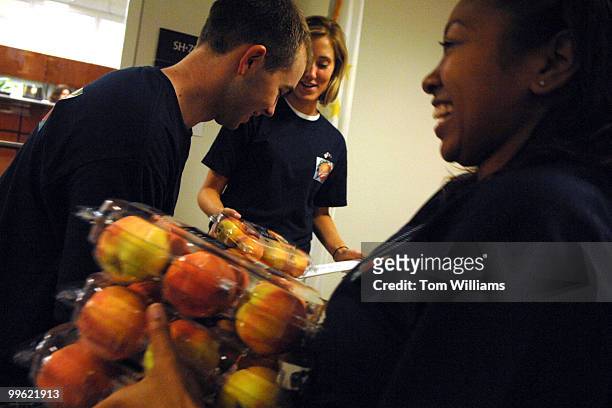 From left, Sean Evins, Allison Humen, and Lakisha Lockhart, Sen. Jim DeMint, R-S.C., interns, hand out peaches to offices in Hart Building as to...