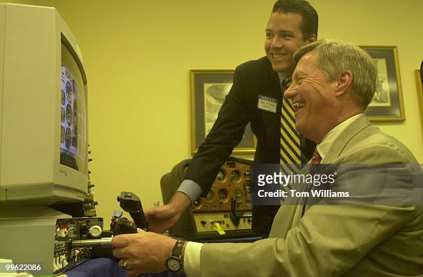 John Williams of the Aircraft Owner and Pilots Association assists Rep. Collin Peterson as he tries out a new flight simulator. The AOPA hosted the...