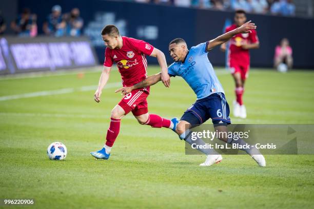 Alex Muyl of New York Red Bulls tries to get past Alexander Callens of New York City during the Major League Soccer Hudson River Derby match between...