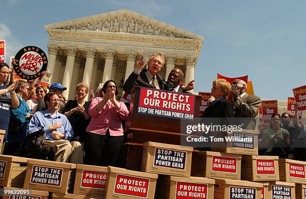 Senate Majority Leader Harry Reid, D-Nev., puts his arm around Rep. John Lewis, D-Ga., and addresses the crowd, at a rally held in front of the...