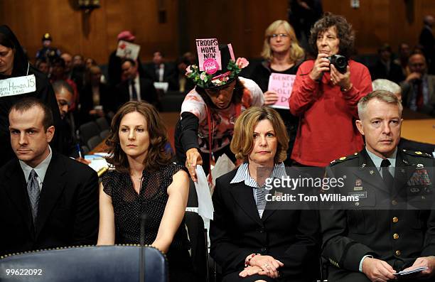 Desiree Fairooz of Code Pink, tries to hand a document to members of Gen. David Petraeus's entourage before a hearing of the Senate Armed Services...