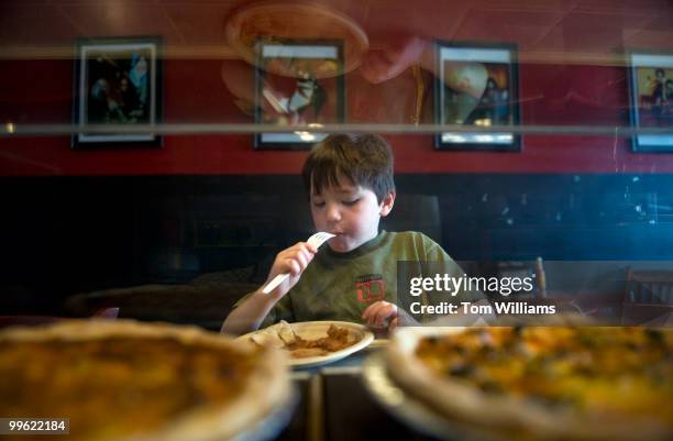 Waylon Henry son of Rodney Henry, co-owner of Dangerous Pies on H Street, NE, enjoys an apple pie at the counter, April 5, 2010.