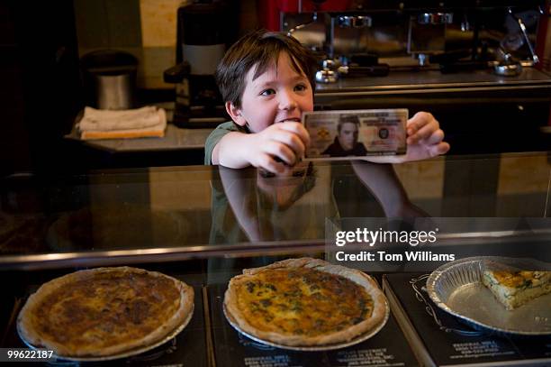 Waylon Henry son of Rodney Henry, co-owner of Dangerous Pies on H Street, NE, displays a fake dollar bill at the counter, April 5, 2010.