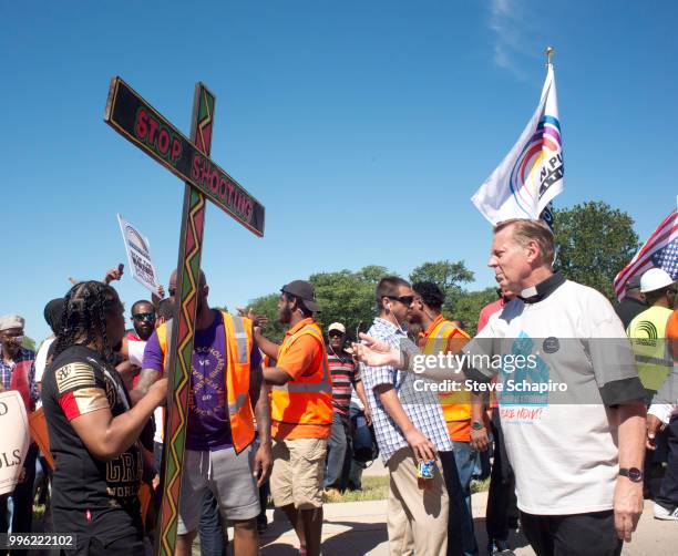 View of Father Michael Pfleger , activist and pastor of St Sabina parish, and unidentified others during a anti-violence protest, Chicago, Illinois,...