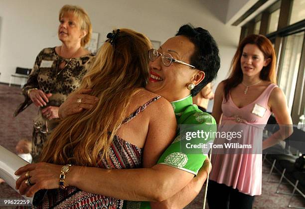 Win-Ling Chestnut, widow of Officer J.J. Chestnut, killed in 1998, hugs Shannen Saboungian, whose father Sgt. Chris Eney, was killed in 1984, as...