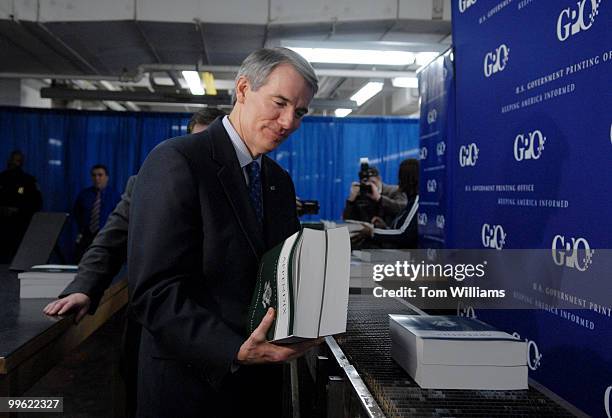 Office of Management and Budget Director Rob Portman, inspects a copy of The Budget of the United States Government, Fiscal Year 2008, at the GPO...