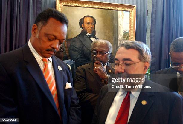From left, Rev. Jesse Jackson, Reps. Jim Clyburn, G.K. Butterfield, D-N.C., and Bobby Rush, D-Ill., bow their heads in prayer after the portrait of...