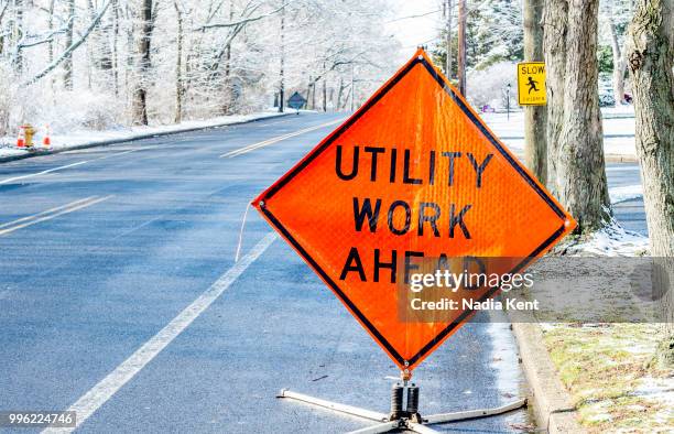 utility work sign on a clean wintery road - nadia stock pictures, royalty-free photos & images