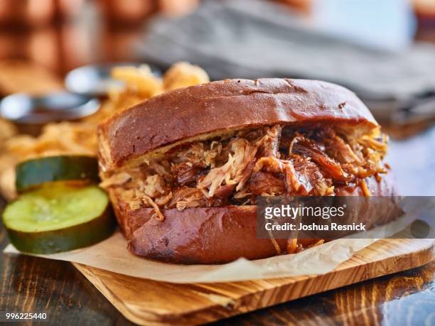barbecue pulled pork sandwich with dripping sauce served with pickles - pickles - fotografias e filmes do acervo