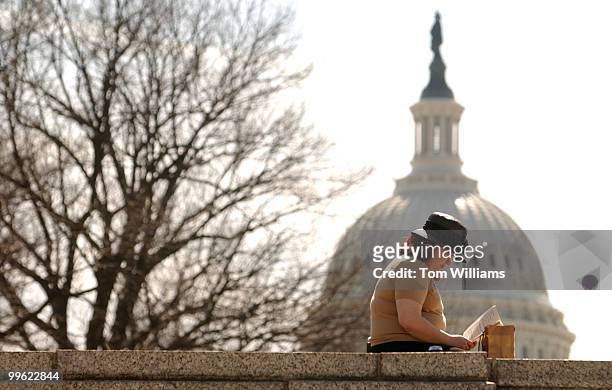 Amy Bierer reads a book during the lunch hour in Upper Senate Park, Monday.