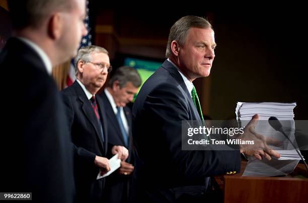 Sen. Richard Burr, R-N.C., picks up the 2000 + page health care bill during a news conference with, from left, George LeMieux, R-Fla., Senate...