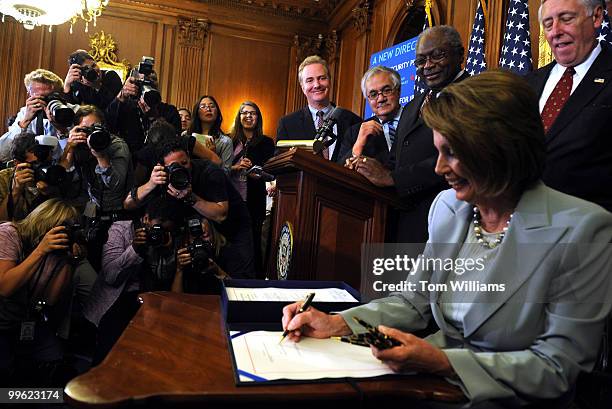 Speaker Nancy Pelosi, D-Calif., signs the Emergency Economic Stabilization Act, after the House passed the legislation, October 3, 2008. Also...